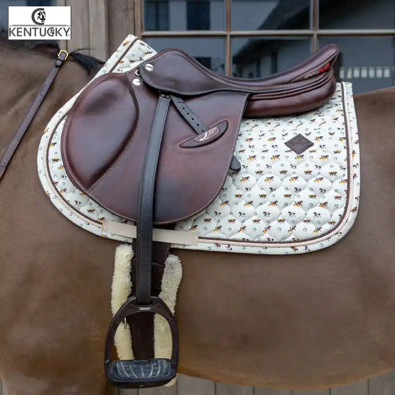 Le Tapis de Selle Velvet Horse Printing Jumping Beige KENTUCKY est un tapis d'équitation de forme Mixte/Jumping qui allie luxe, originalité et performance.