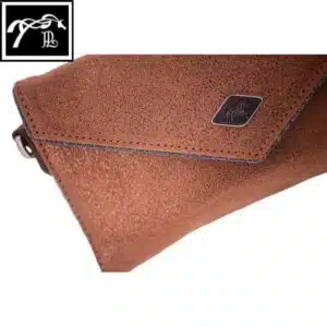 Détail cuir pailleté Cognac Glitter Détail du cuir pailleté et du liseré brillant de la Pochette Pénélope Cognac Glitter