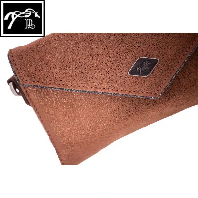 Détail du cuir pailleté et du liseré brillant de la Pochette Pénélope Cognac Glitter