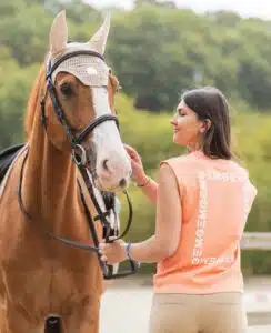 Vêtements GEM Équitation Cavalière portant des vêtements techniques GEM lors d'une séance d'équitation.