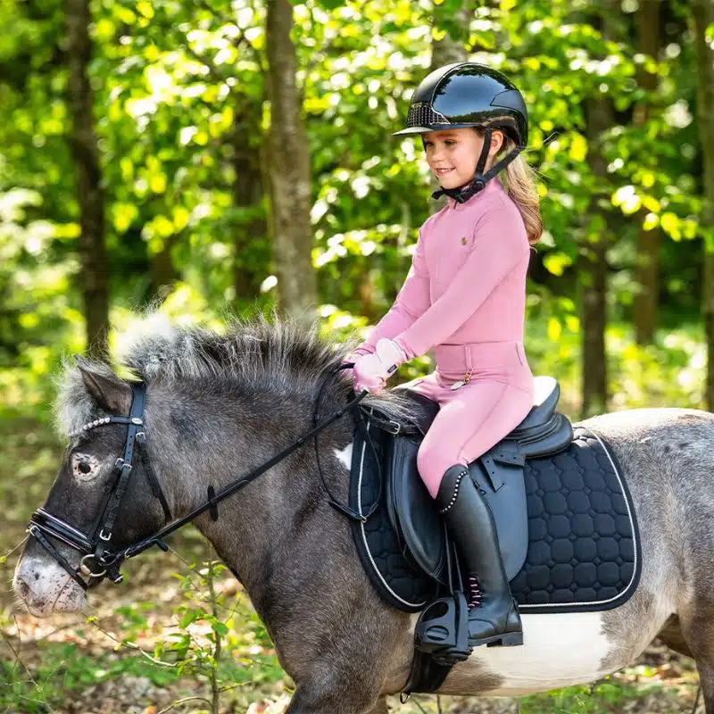 ALT : Jeune cavalière à poney avec Polo d'équitation Lucky Start Junior QHP