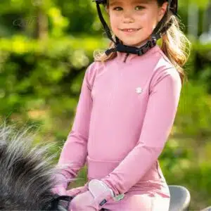 Polo d'équitation Lucky Start Junior QHP rose porté par une jeune cavalière Polo d'équitation Lucky Start Junior QHP rose porté par une jeune cavalière
