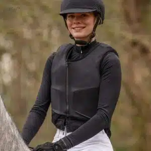 Housse Glitter pour gilet de cross QHP noir pailleté porté par une cavalière à cheval Housse glitter sur gilet de protection QHP porté par une cavalière