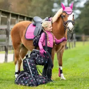 Sac de pansage Isalyn QHP noir pailleté licorne vue en situation avec une jeune cavalière et son poney Sac de pansage Isalyn QHP noir pailleté licorne vue en situation avec une jeune cavalière et son poney