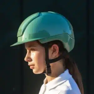 Cavalière en tenue de concours portant un casque KASK Nemesi Mint Green shiny