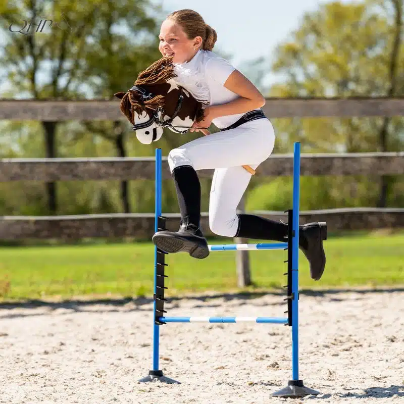 Enfant en tenue de concours sautant un obstacle avec un Hobby Horse QHP