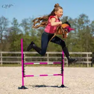 Enfant sautant un obstacle avec un Hobby Horse QHP en tenue d'entraînement
