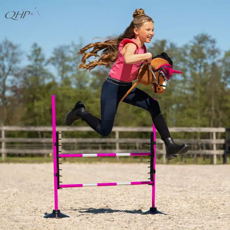 Enfant sautant un obstacle avec un Hobby Horse QHP en tenue d'entraînement