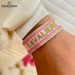 Bracelet Cavalière rose EQUESTRIAN SHOP avec broderie dorée porté au poignet