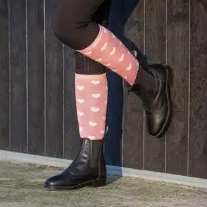 Chaussettes d’équitation hautes rose poudré à cœurs portées par Cavalière portant des chaussettes d’équitation hautes rose poudré avec motifs cœurs