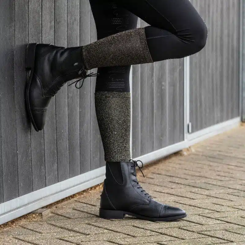 Cavalière portant une chaussette d’équitation noire et or pailletée QHP