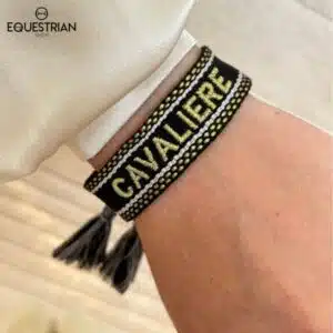 Bracelet Cavalière noir EQUESTRIAN SHOP en tissu brodé doré porté au poignet