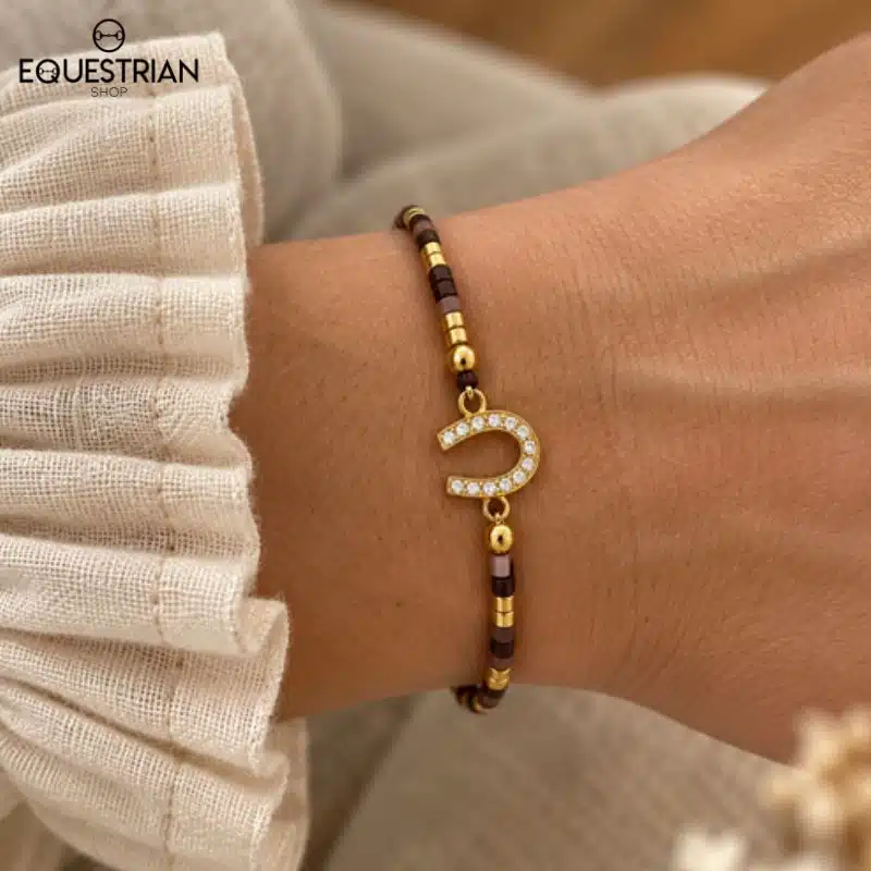 Bracelet Summer EQUESTRIAN SHOP coloris chocolat porté au poignet, avec fer à cheval serti de strass et détails dorés