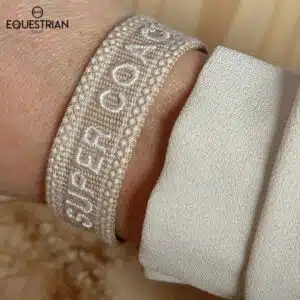 Bracelet Super Coach EQUESTRIAN SHOP beige avec broderie blanche porté au poignet